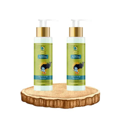 Two Ashira Ayurvedic anti-dandruff shampoo bottles with gold pumps on wooden slice