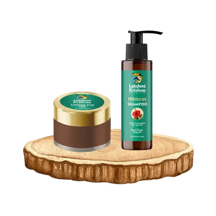 Lakshmi Krishna natural under eye gel and hibiscus shampoo on wooden platform for skincare and hair care